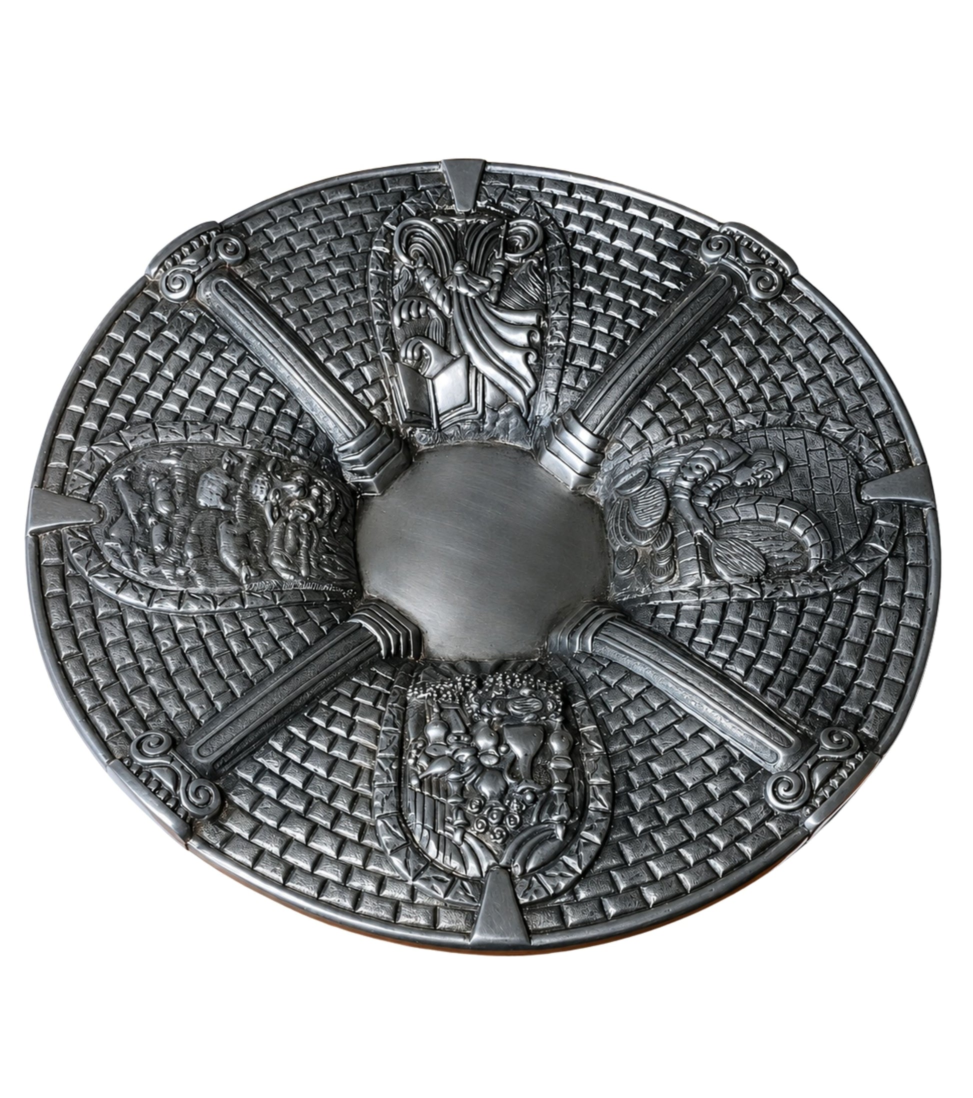 Sterling silver Passover Seder plate with four sculptural narrative relief panels depicting Moses and the Exodus, matzah preparation, the Paschal lamb, and a festive holiday table, framed by classical columns and Jerusalem stone-inspired textures.