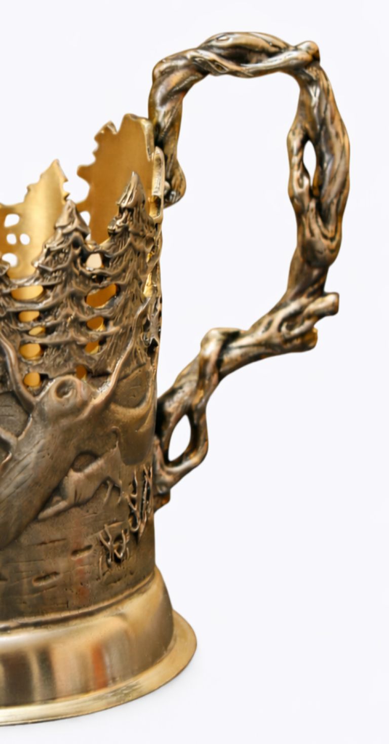 Detailed relief on sterling silver winter story cup holder featuring hunters, wildlife, textured snow terrain, and traditional seasonal life in high-relief sculptural engraving