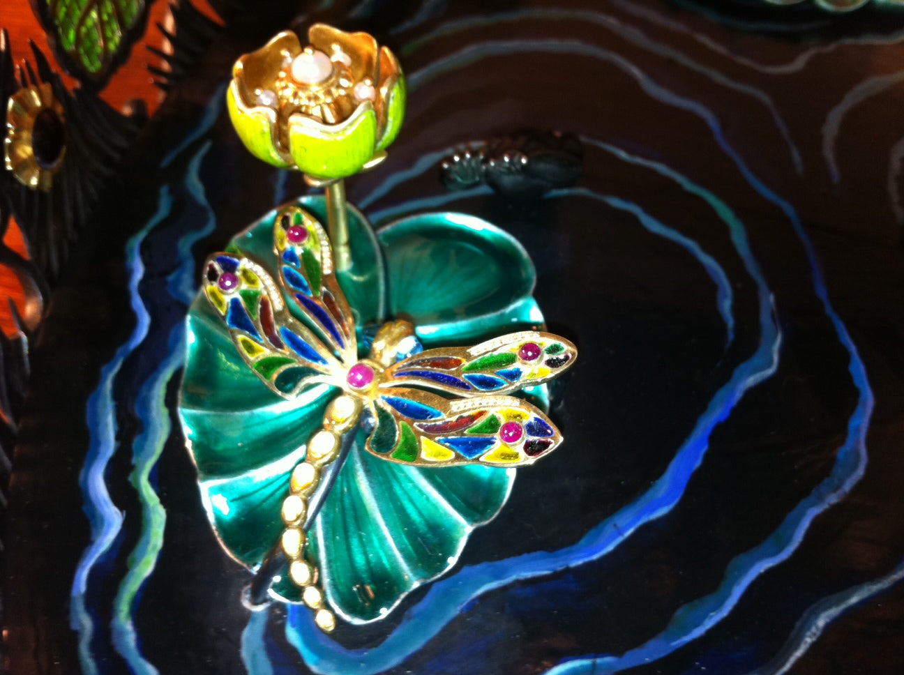 Detail of a dragonfly resting on a lily pad in the “Summer Pond” centerpiece, combining sculptural carving, gemstone accents, and refined metalwork.