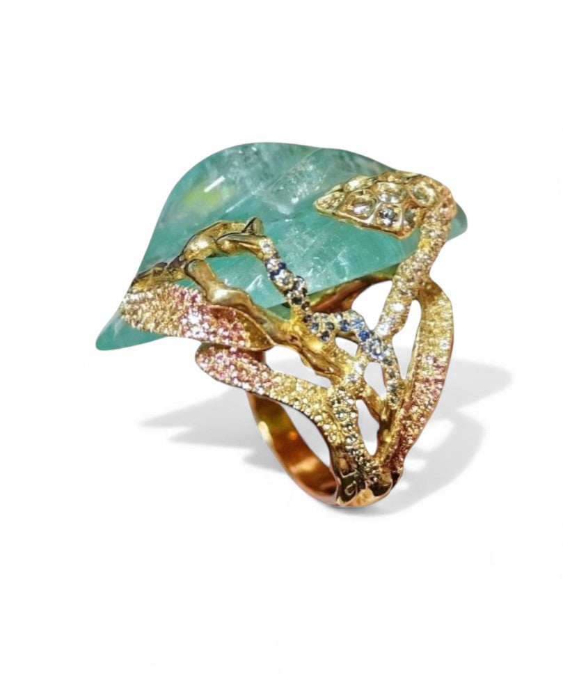 Side profile of the Summer Pond 18K gold ring highlighting the dimensional aquamarine carving, layered enamel colors, and sapphire accents.