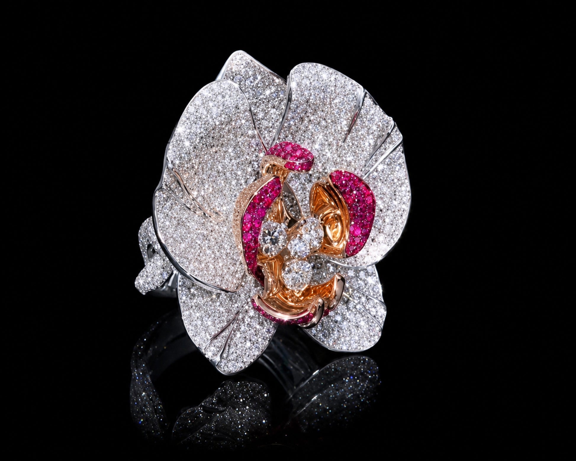 Handcrafted Empress Orchid cocktail ring in 18K white gold with white rhodium, featuring pavé-set diamonds across sculptural orchid petals, vivid ruby-set inner petals in pink gold, and four round brilliant center diamonds.