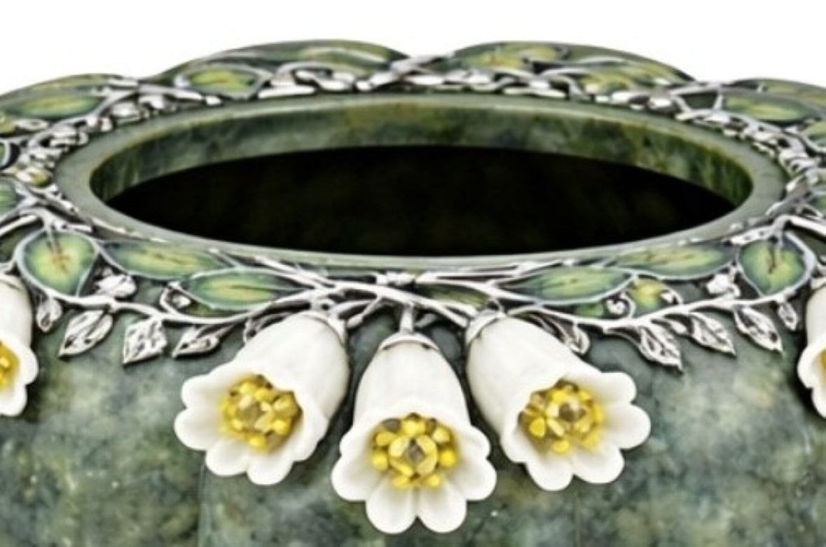 Close up of white jade bluebell flowers with yellow sapphire centers set in silver, part of a handcrafted nephrite jade tea set